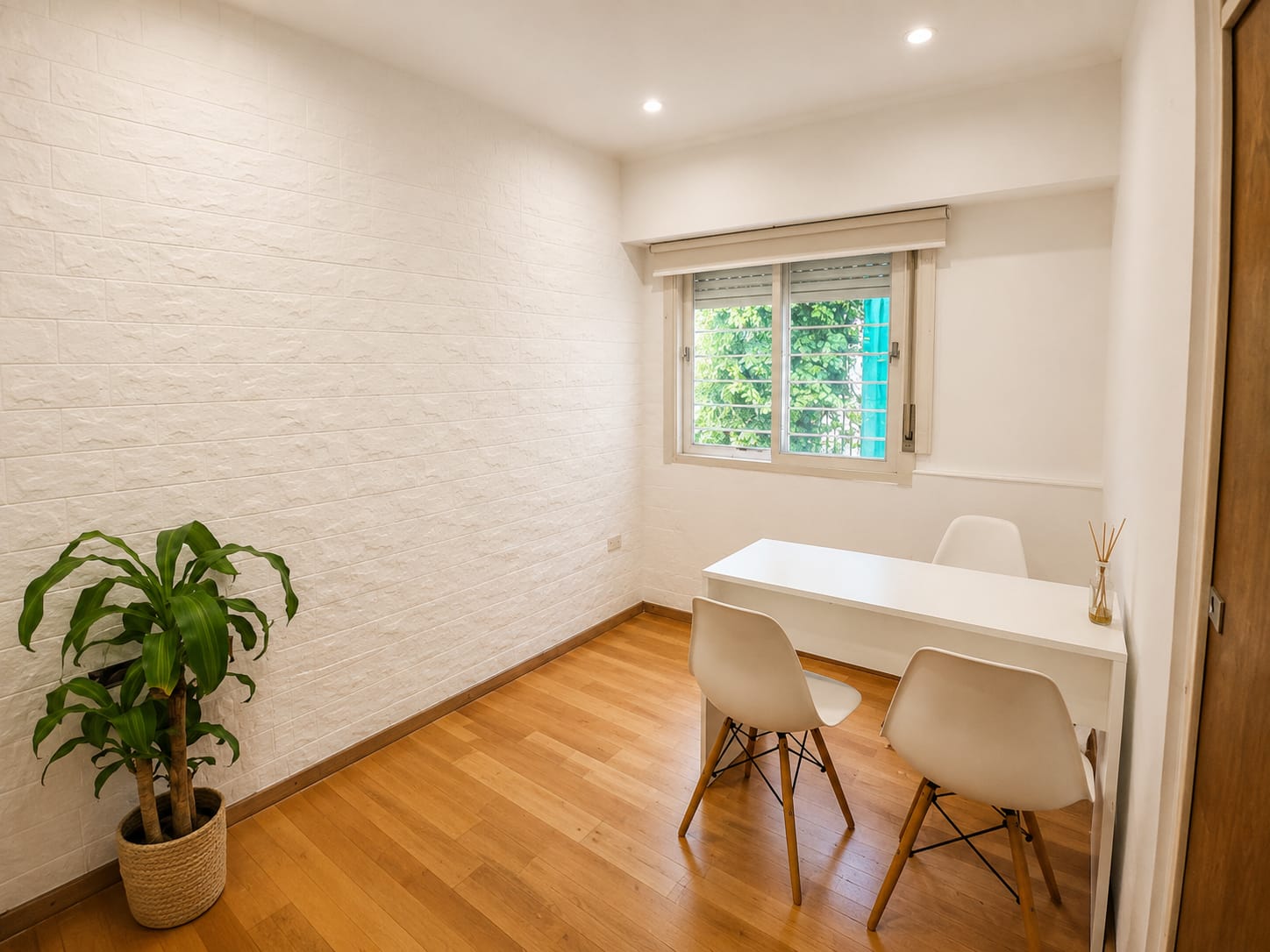 Habitación de consulta luminosa con pared de ladrillo blanco